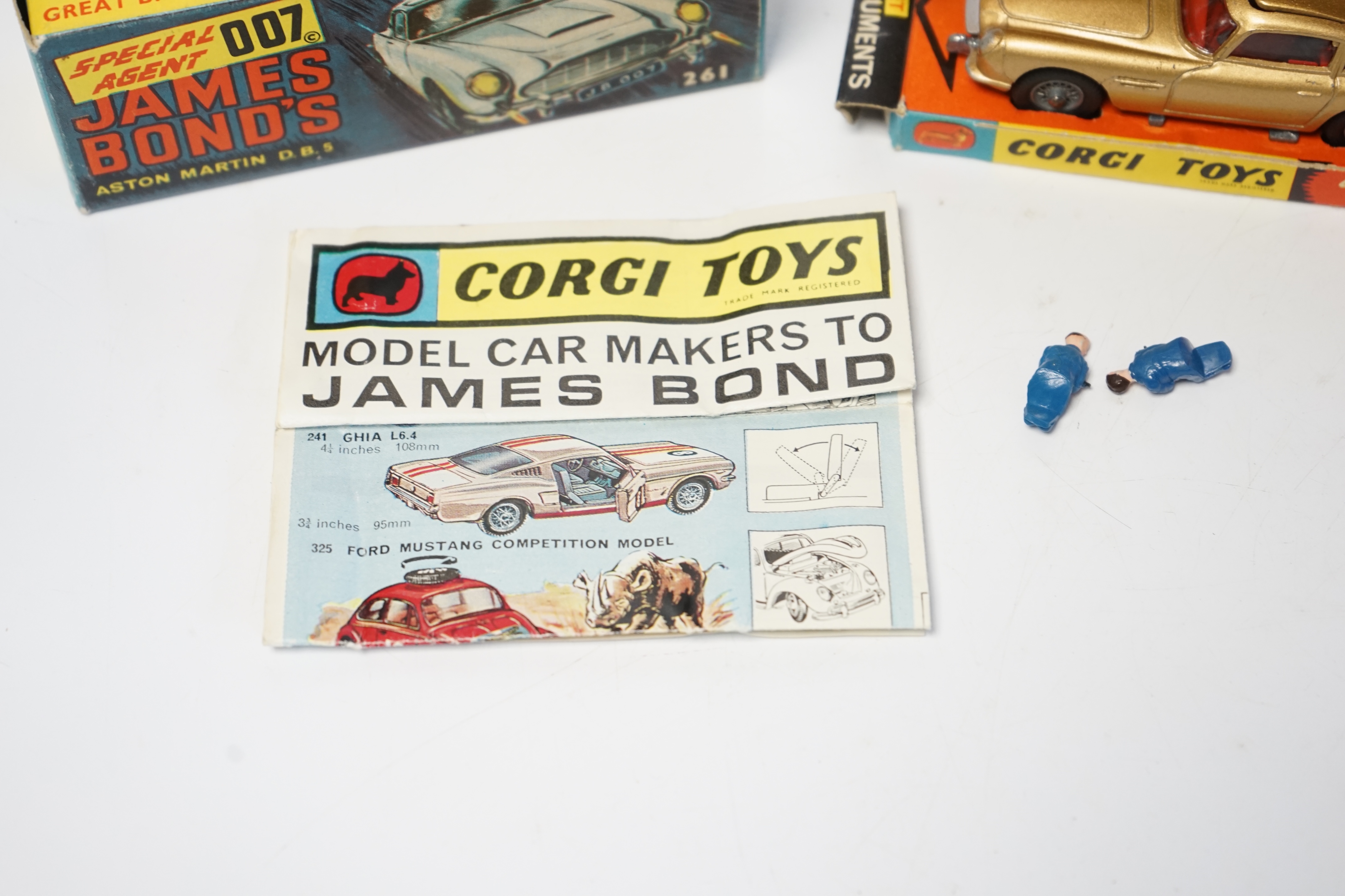 A boxed Corgi Toys James Bond 007 Aston Martin (261), a first issue example in gold finish, boxed with inner display stand, envelope for secret instructions, top-secret leaflet, sheet of two unused lapel stickers, and th